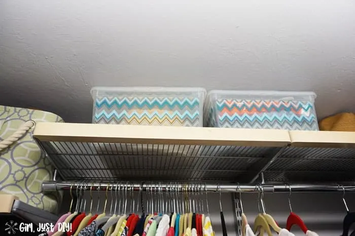 Top shelf of closet with two plastic bins.