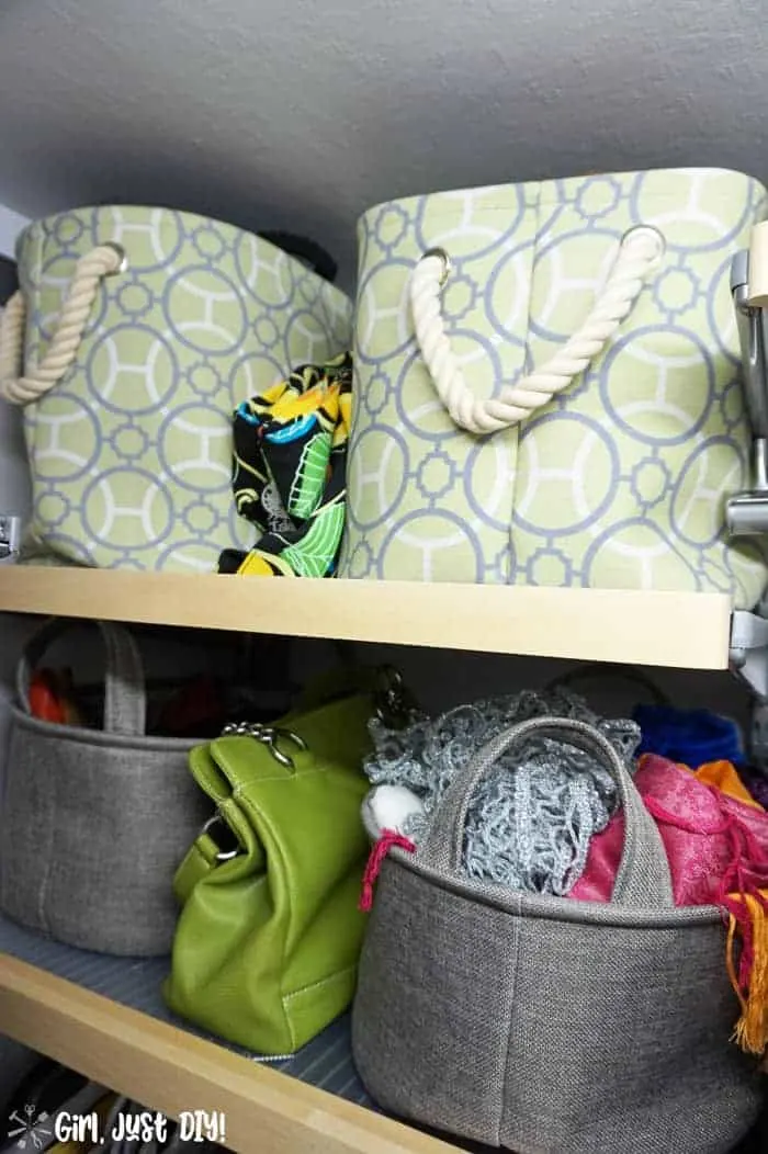 Fabric bins on closet shelves stuffed with scarves and purses.