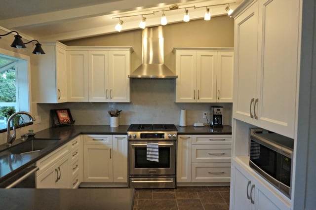 Kitchen Renovation completed looking over bar counter top. Microwave on right in pantry cabinet.