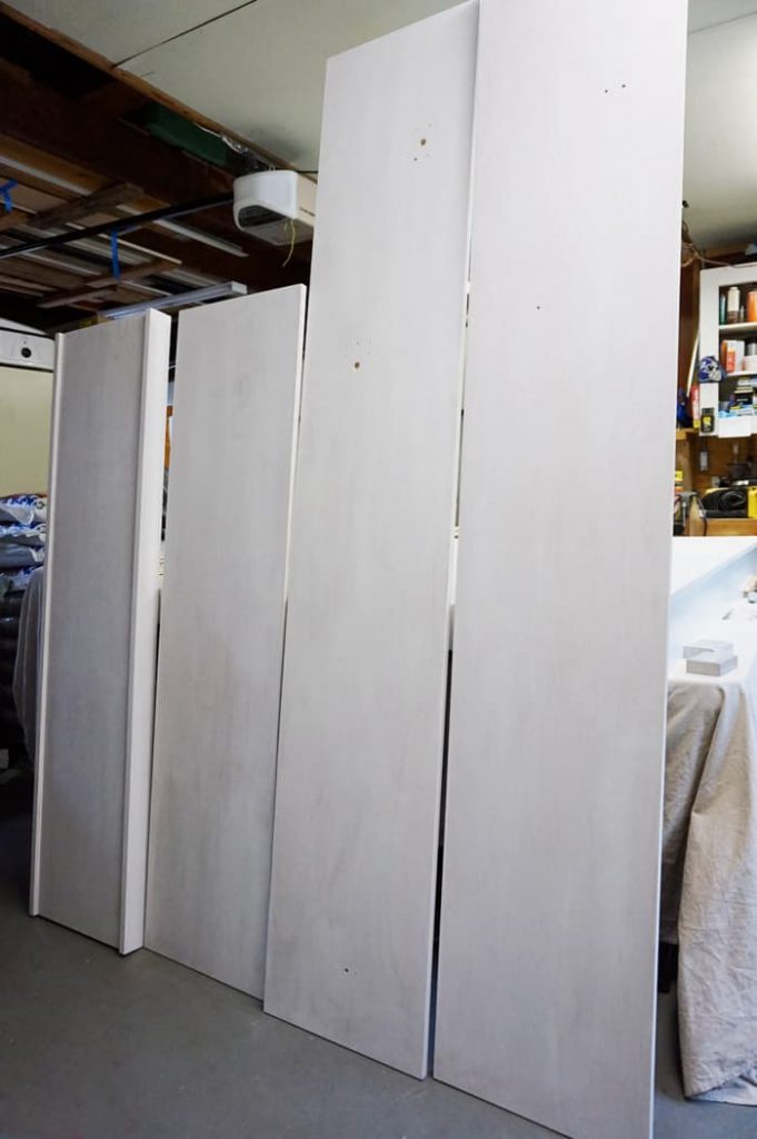 Pre-painted murphy bed pieces standing in garage.