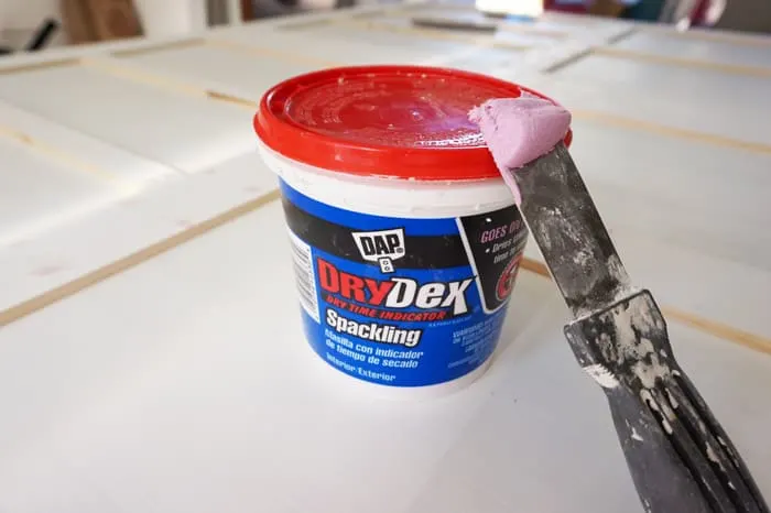 Putty knife with pink spackle