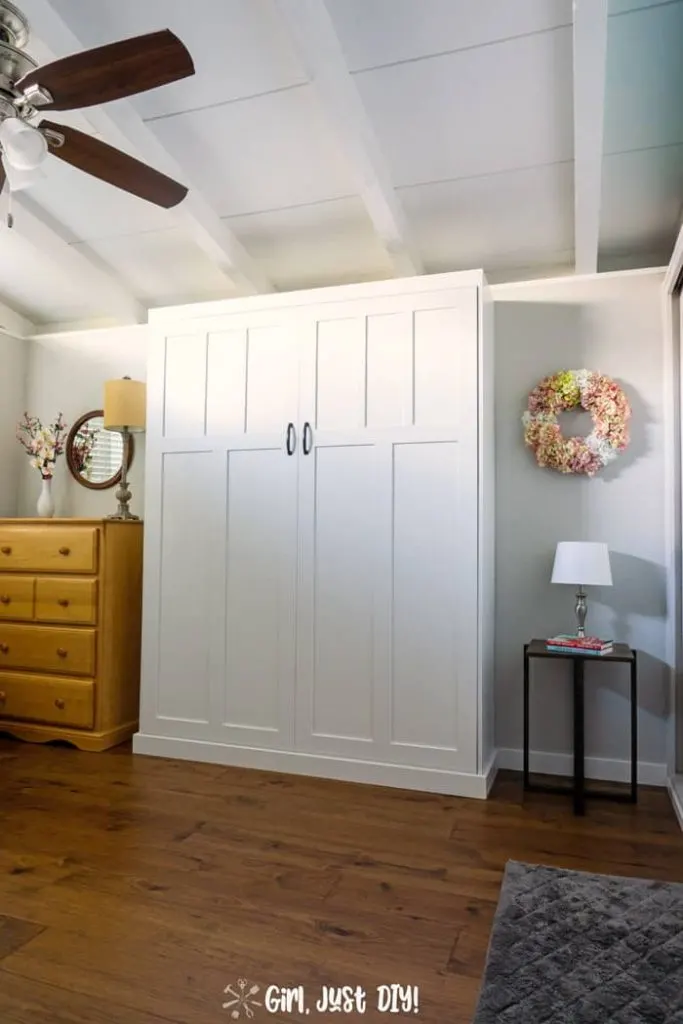 Closed Murphy Bed wall bed flanked by dresser and side table.