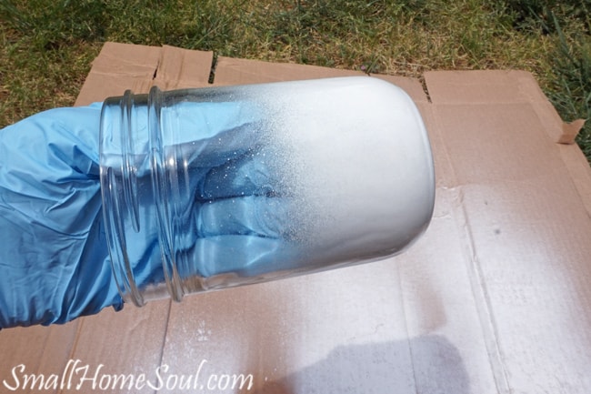 Gloved hand in jar and spray painting.