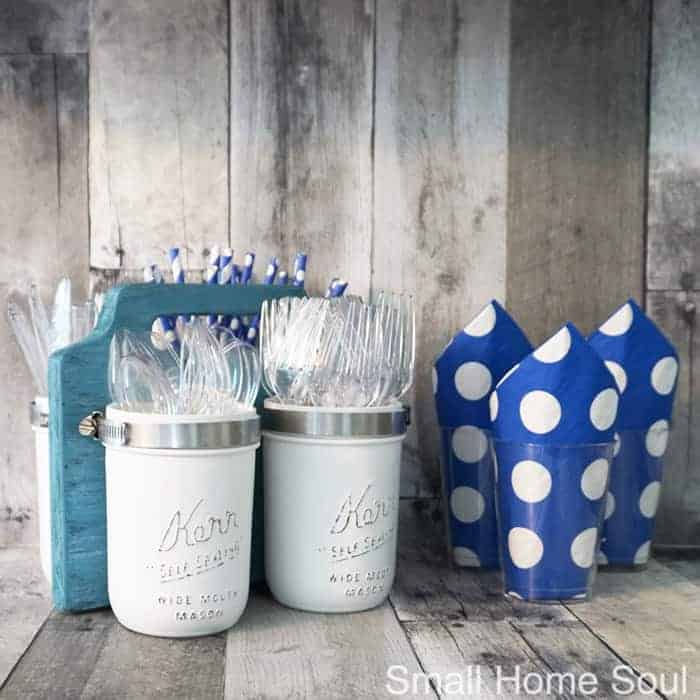 DIY Mason Jar Utensil Caddy with utensils and straws next to blue polka dot napkins
