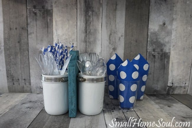 The mason jar utensil caddy is filled with plasticware and ready for a party.