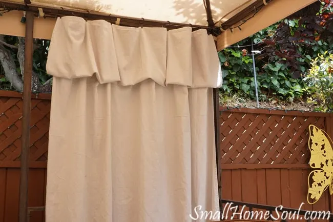 Drop cloth hung on curtain clips with the top folded over into a valance.