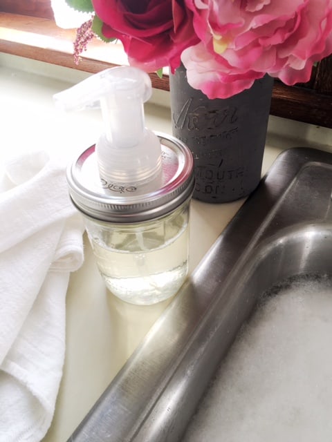 Mason jar with foaming pump next to kitchen sink