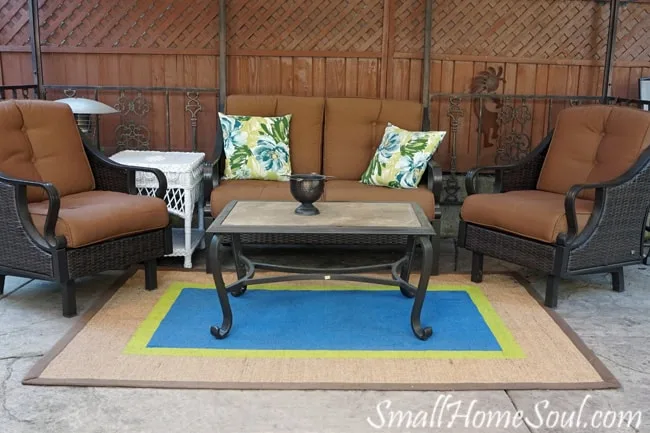 Painted seagrass rug on the patio with blue and green brightens up the seating area.