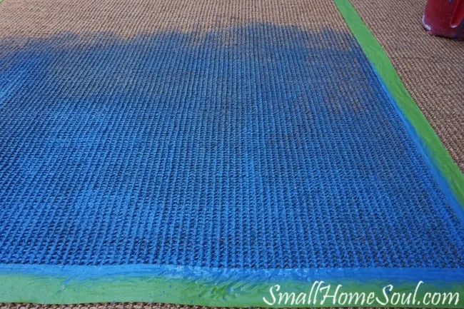 Painting a seagrass rug with blue in the center.