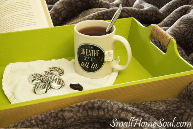 Beachy serving tray on bed with cup of tea and pile of thin mints.