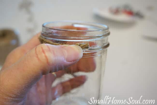 threaded top of mason jars wrapped with jute twine.