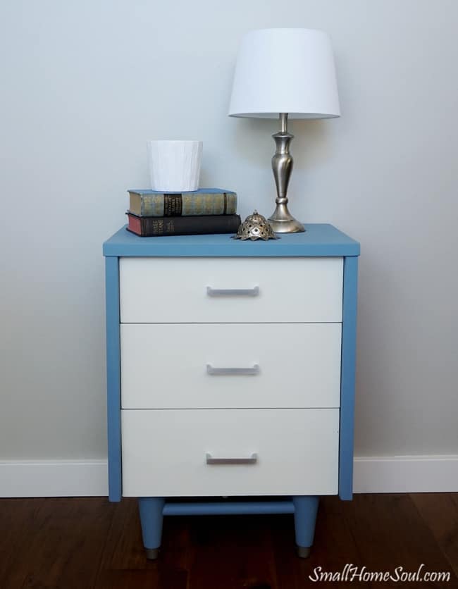 Completed blue and white mid-century modern dresser topped with a lamp and books.