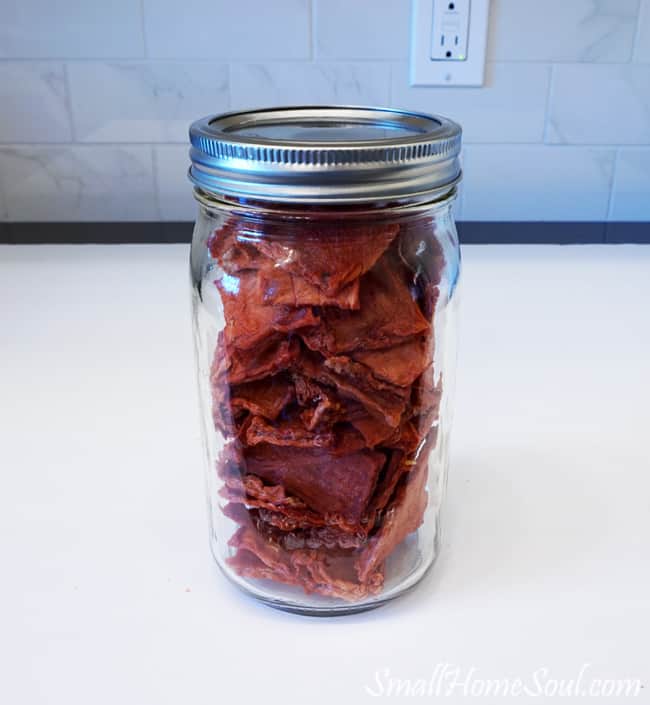 Watermelon candy in a quart jar on counter top.