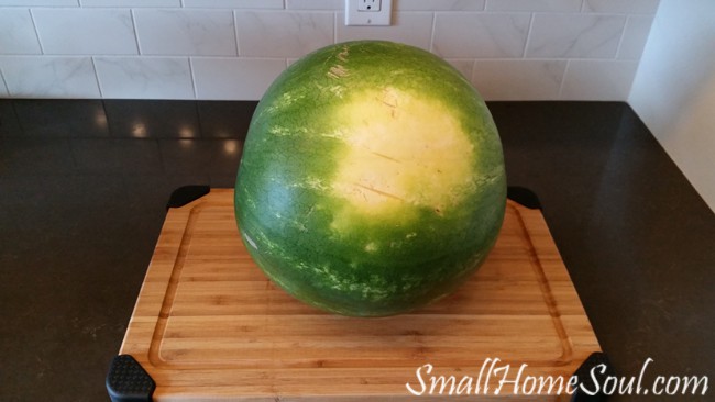 Whole watermelon on cutting board on counter top.