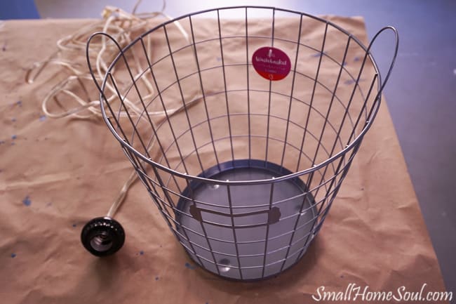 Wire basket and light kit on butcher paper.