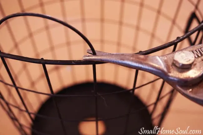 Using tin snips to remove metal handles from wire basket.