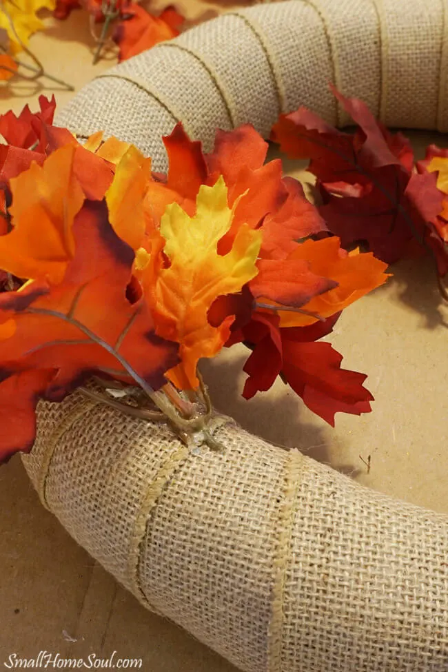 Faux maple leaf stems inserted into burlap wreath.