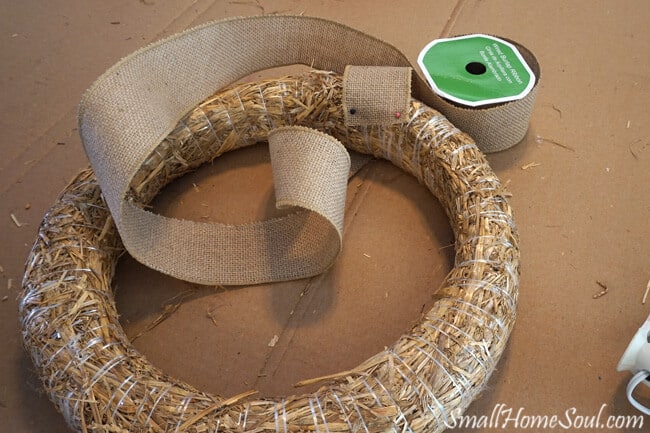 straw wreath form being wrapped with burlap