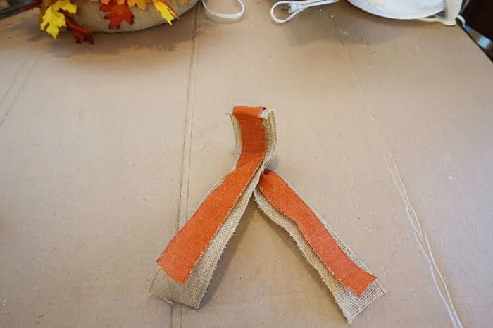 burlap and orange ribbon folded over y bow lengths