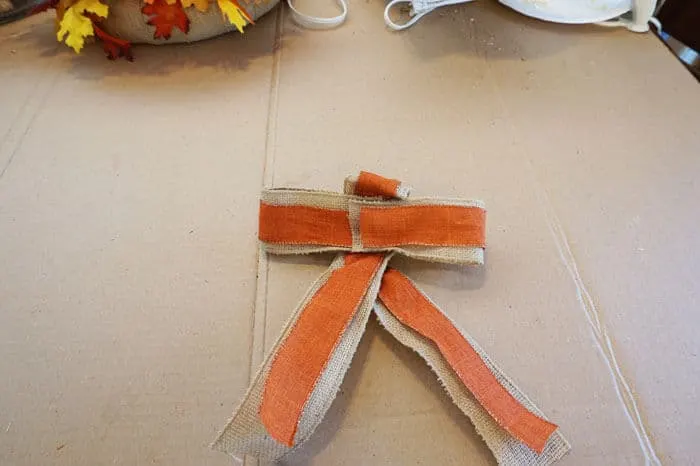 burlap and orange ribbons crossing over bows