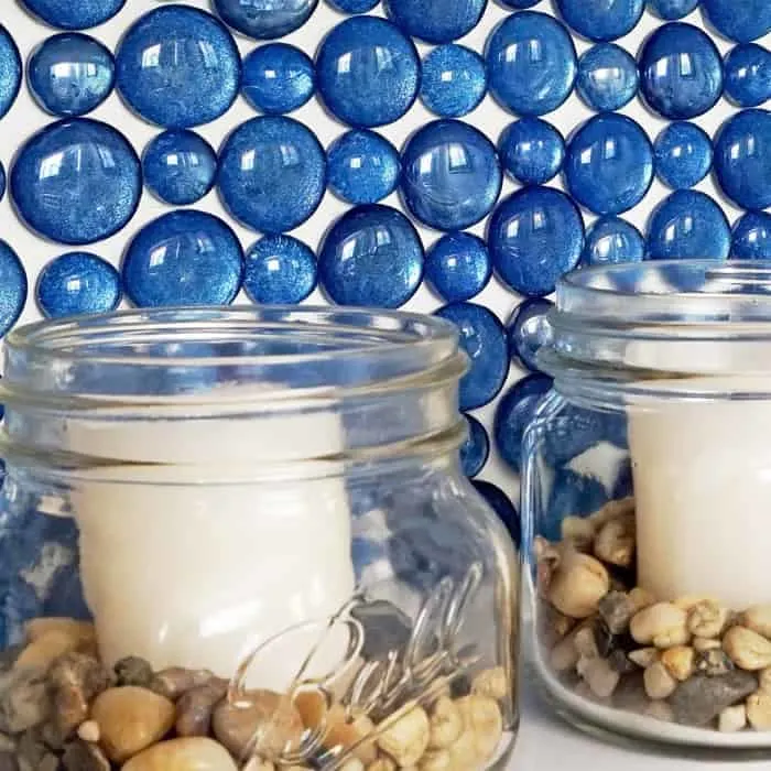 Glass backsplash behind candles in mason jars.