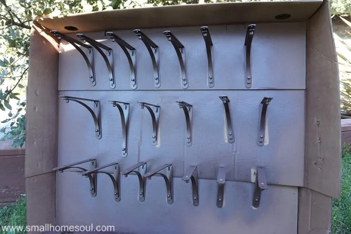 spray painted shelf brackets hanging from cardboard box