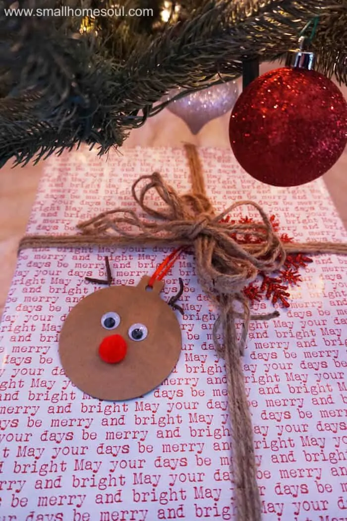 Rudolph Gift Tags tied to a wrapped gift under Christmas tree with ornaments.