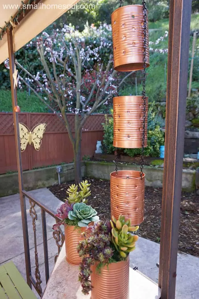 Up close look at hanging recycled tin can lights hanging by chain.