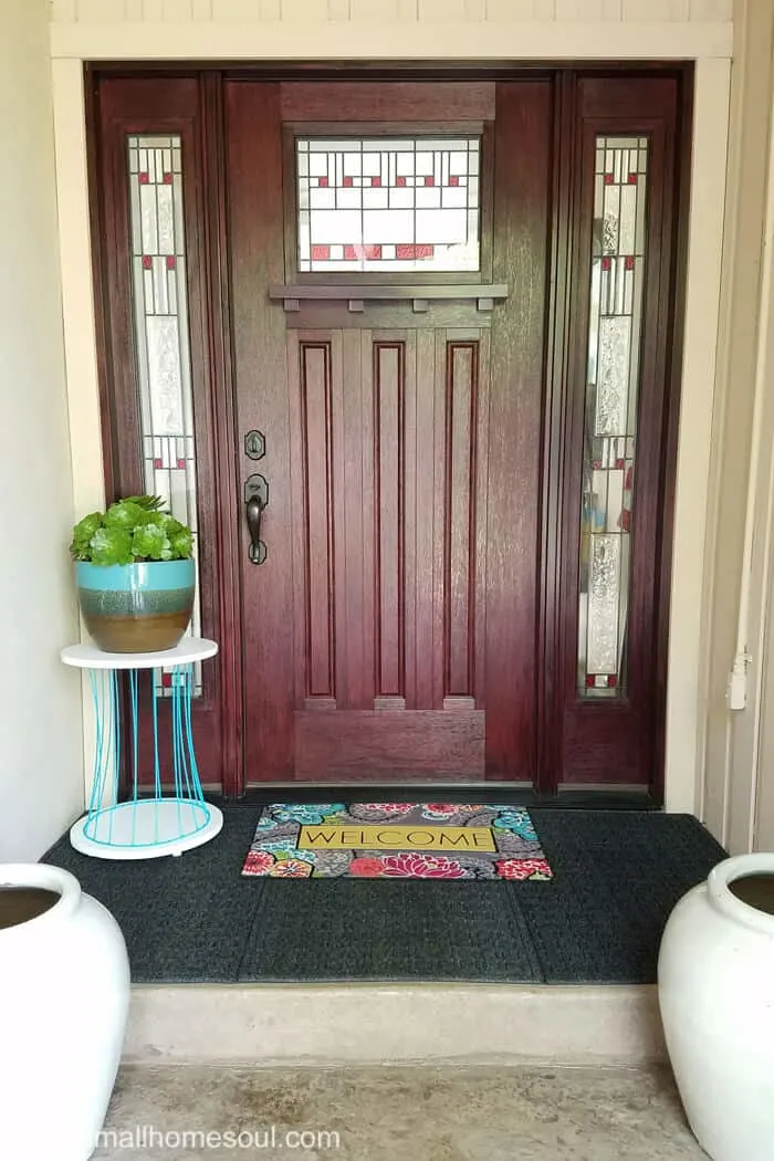 Full shot of DIY outdoor plant stand on front porch.