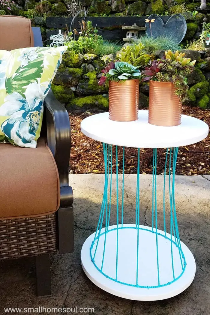 Outdoor plant stand as a side table on patio.