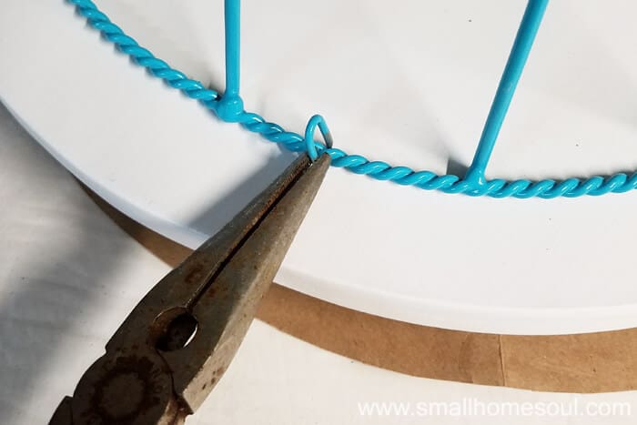 Attaching basket ring to wood top of outdoor plant stand.