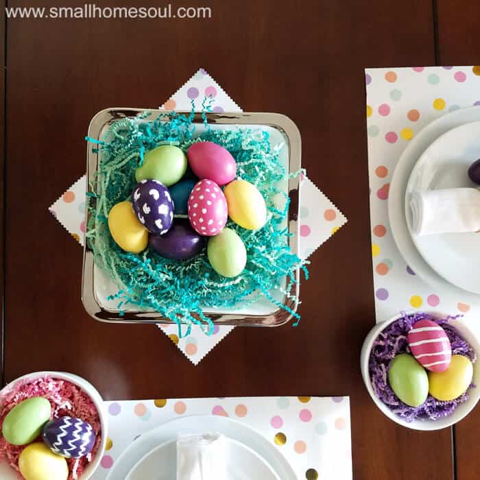 Easter table decorations flat lay of colorful eggs on a cake stand.