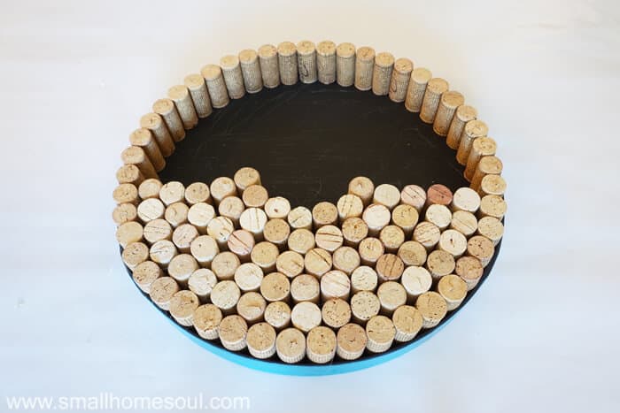 Gluing more corks into lid for DIY wine cork board.