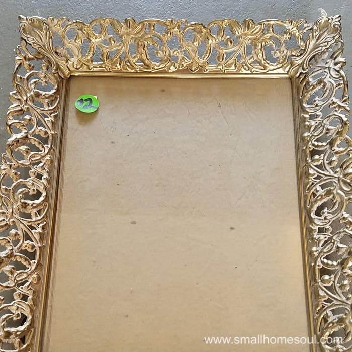 Old metal picture frame with no picture and a $2 green pricetag.