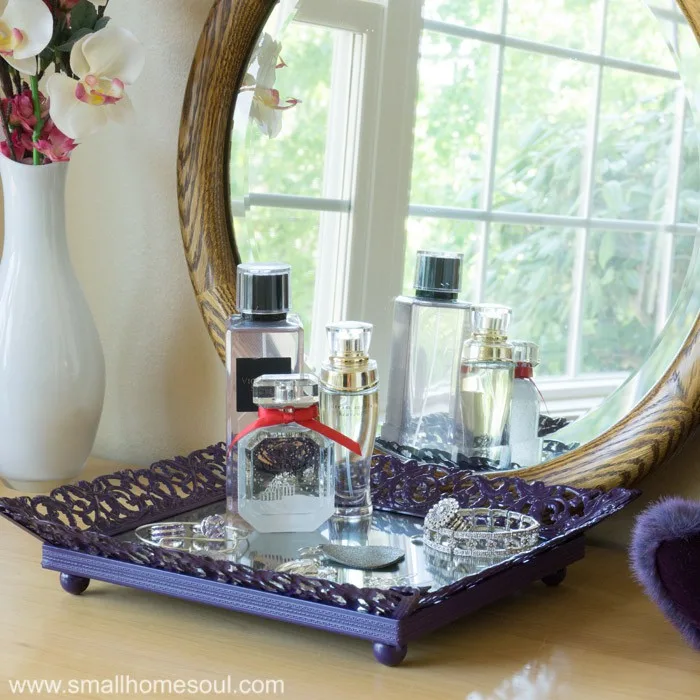Jewelry tray on dresser reflected in mirror.