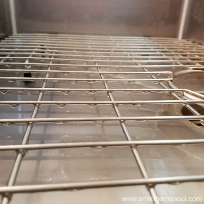 Water droplets hanging from the kitchen sink grid.