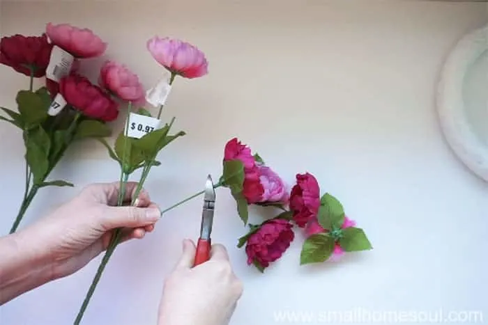 Cutting faux flowers off wire stems with wire cutters.