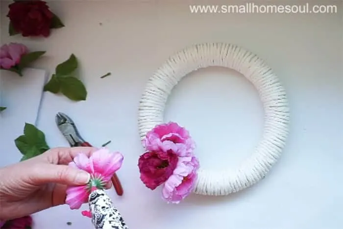 Hot glue flowers onto diy spring wreath.