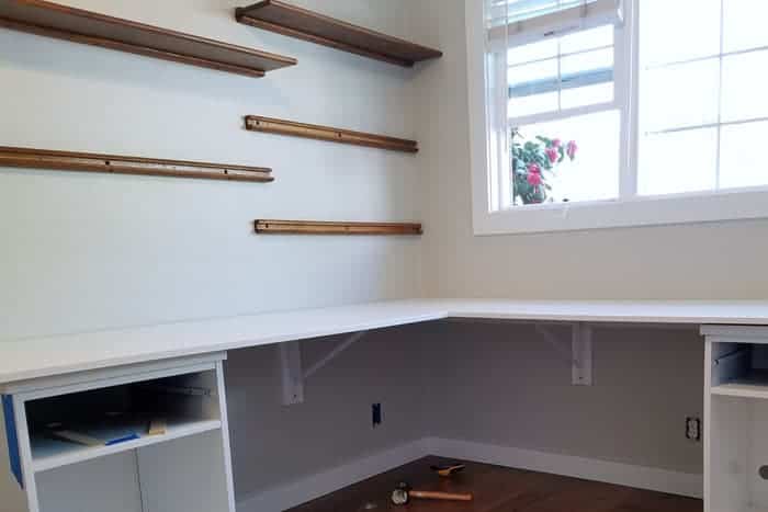 Installed floating wood shelves over desk.