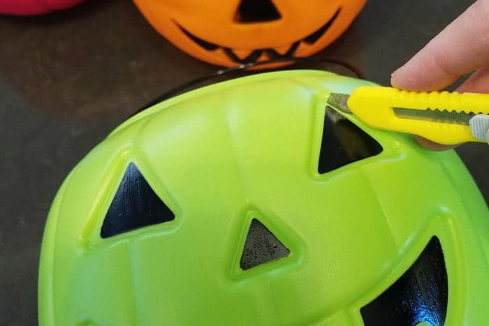 Cutting out eyes of light up pumpkins