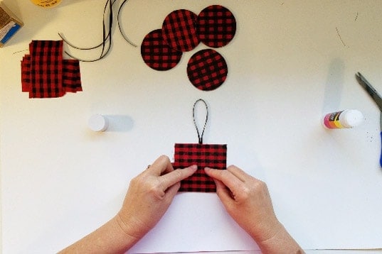 Adding ribbon loop hanger to back of Buffalo plaid ornament.