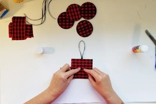 Adding ribbon loop hanger to back of Buffalo plaid ornament.