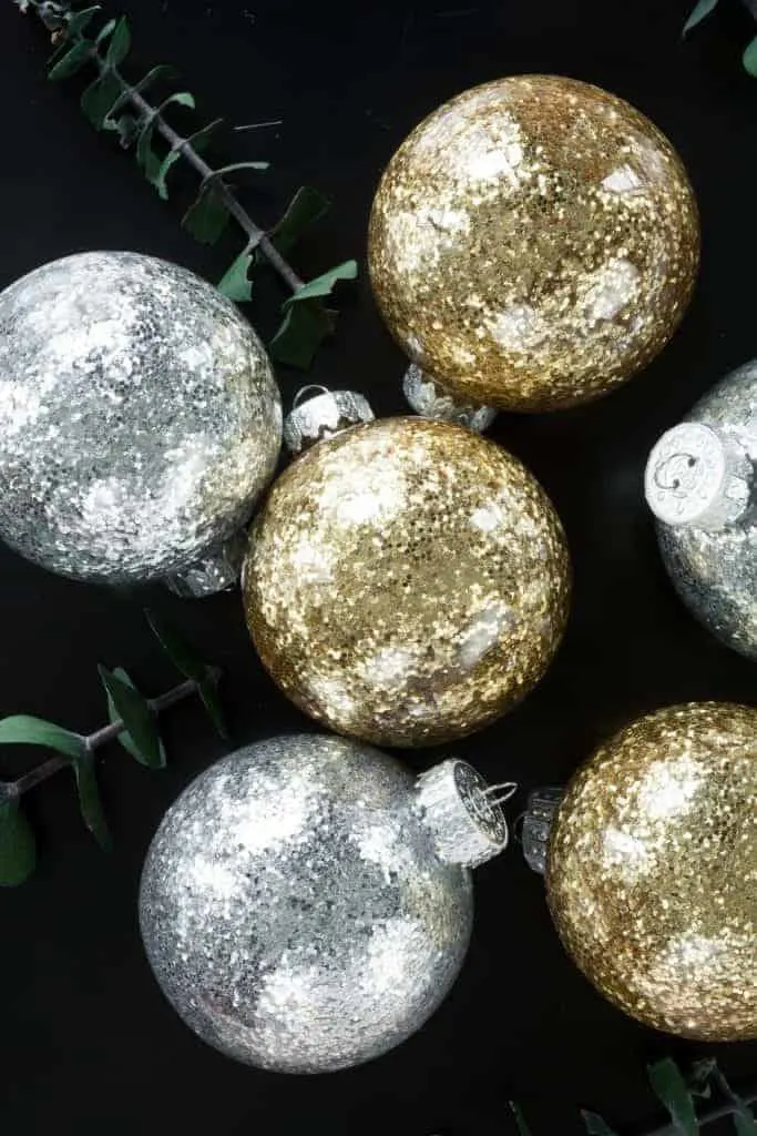 No mess glittery DIY Christmas Ornaments in gold and silver on black background.