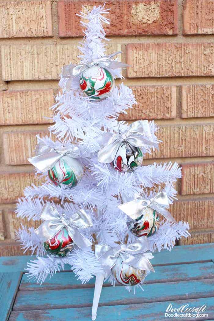 Marbled red green and white DIY Christmas Ornaments on white tree.