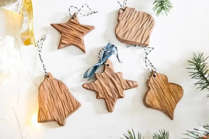 Wood-shaped DIY Christmas Ornaments on white shiplap.