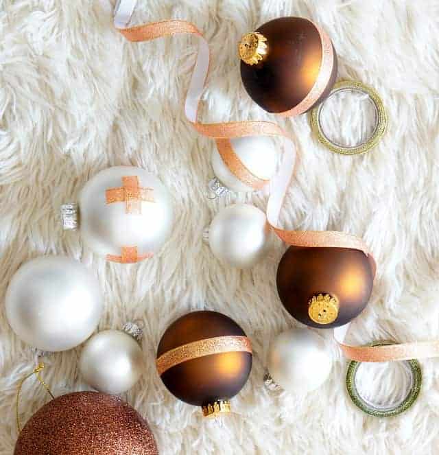White and Copper DIY Christmas ornaments on a white fur rug.