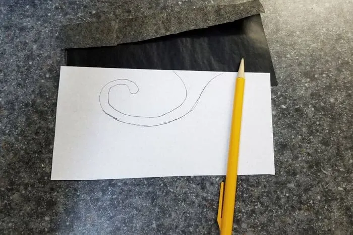 Swirl design on white paper and pencil