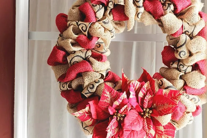 Burlap and red sparkly christmas wreath with red poinsettias.