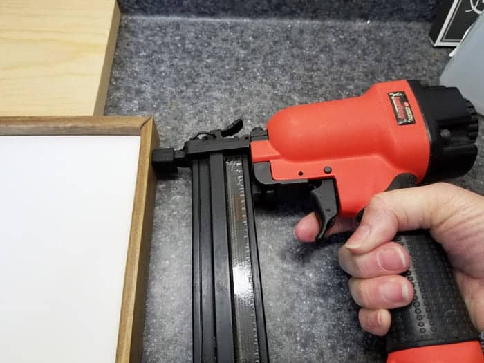 Attaching frame of string art christmas tree with a brad nailer.