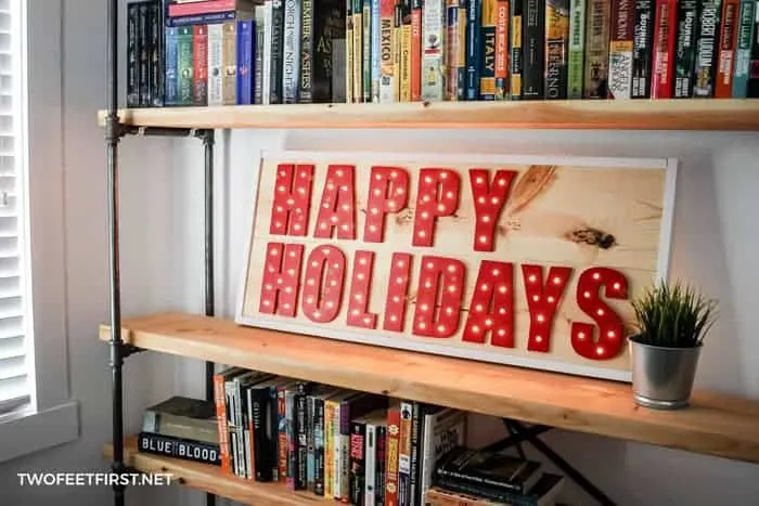 Lighted happy holiday sign red letters on pine board